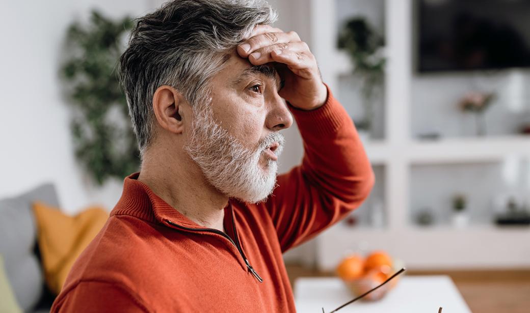 A man wiping his forehead.