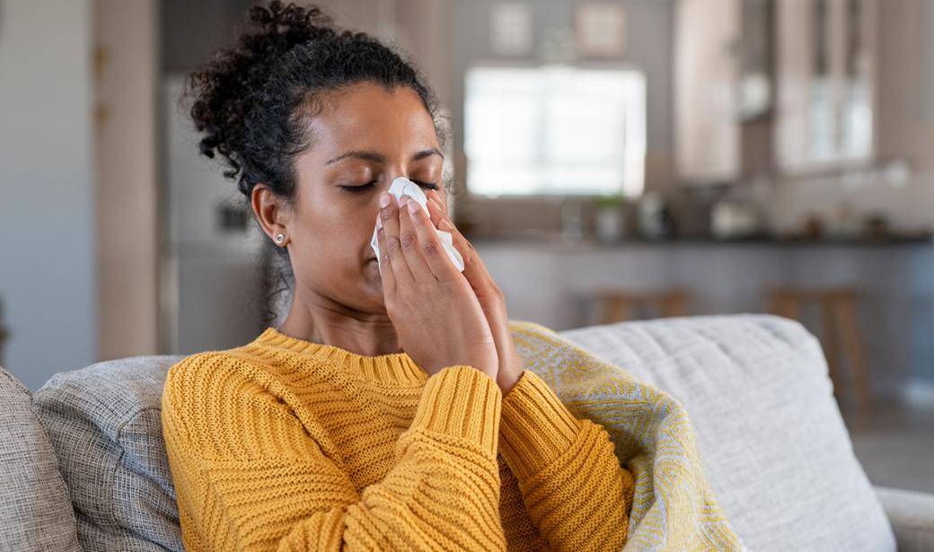 A woman blowing her nose.
