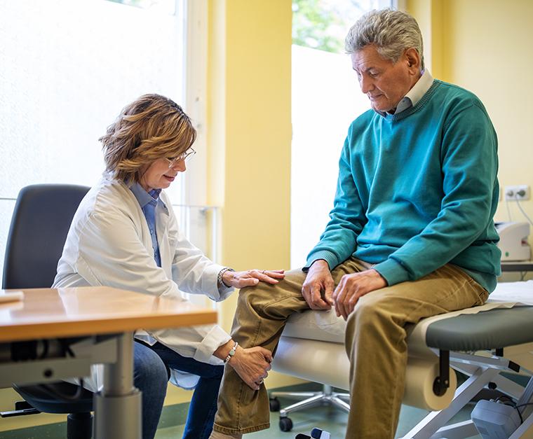 doctor examines mans knee