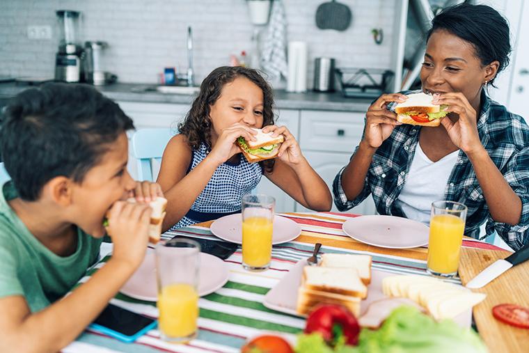 mother and children eating sandwiches