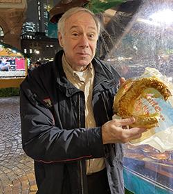 John Benda enjoying a pretzel at a Christmas market in Germany.