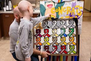 Ezra and dad, Daniel, presenting their Lego ribbon board to MU Health