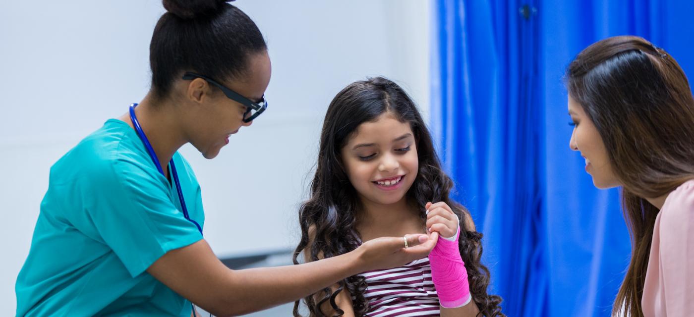 Doctor examining young girl's wrist