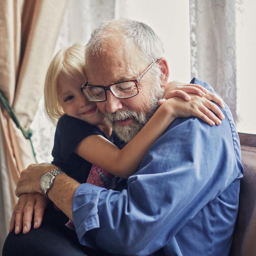 little girl hugging old man 